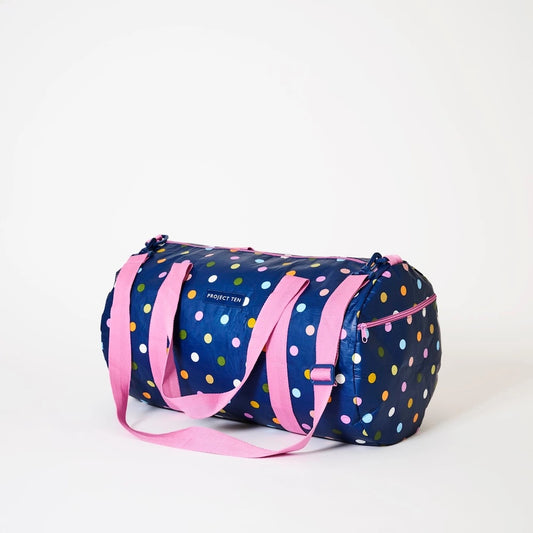 Polka dot duffel bag with pink straps on a white background