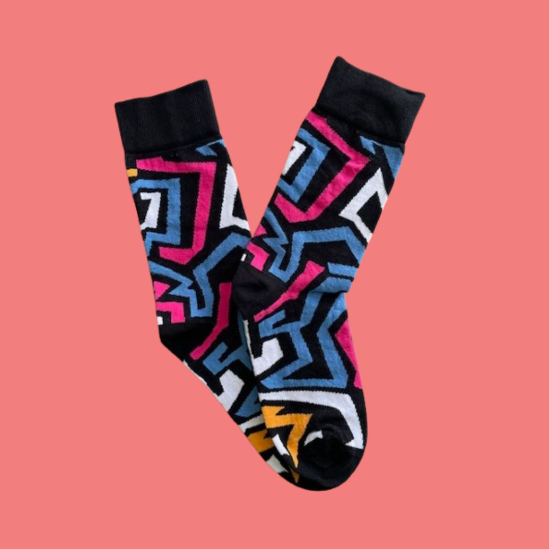 Colorful geometric-patterned socks on a pink background