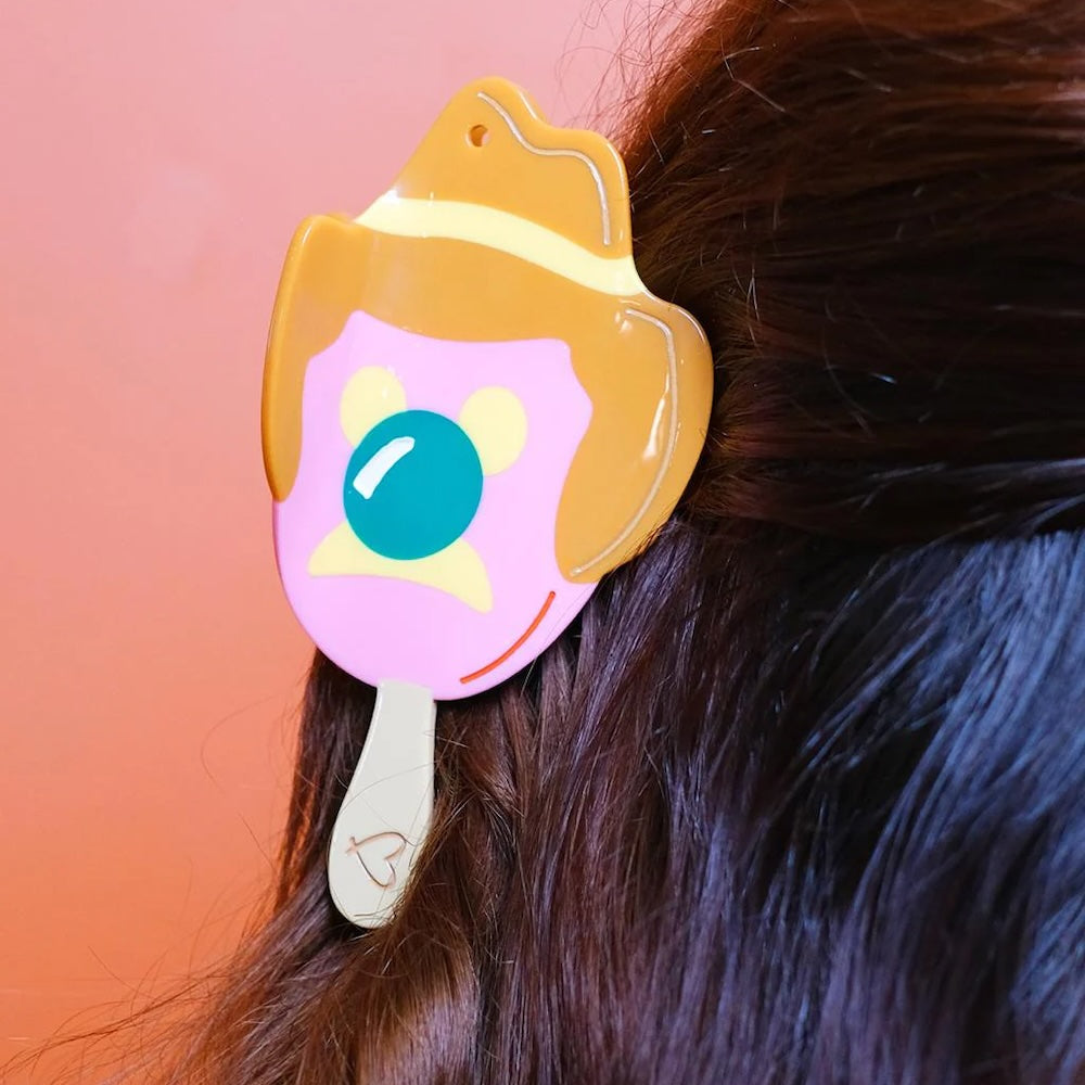 Hair claw shaped like Bubble O' Bill ice cream in dark straight hair.