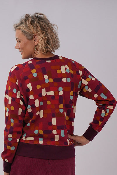 Back view of model wearing Essaye Abstract Sweater in Red