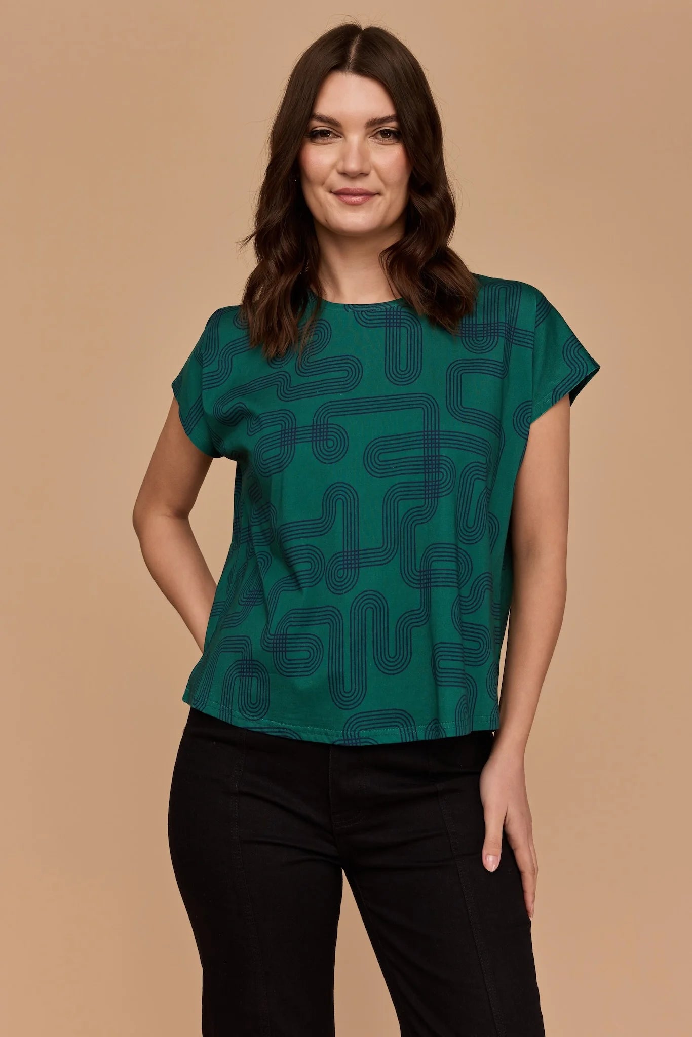 Front view of Model wearing Frock Me Out Labyrinth Capped Sleeve Tee (a green coloured top) and a pair of black pants