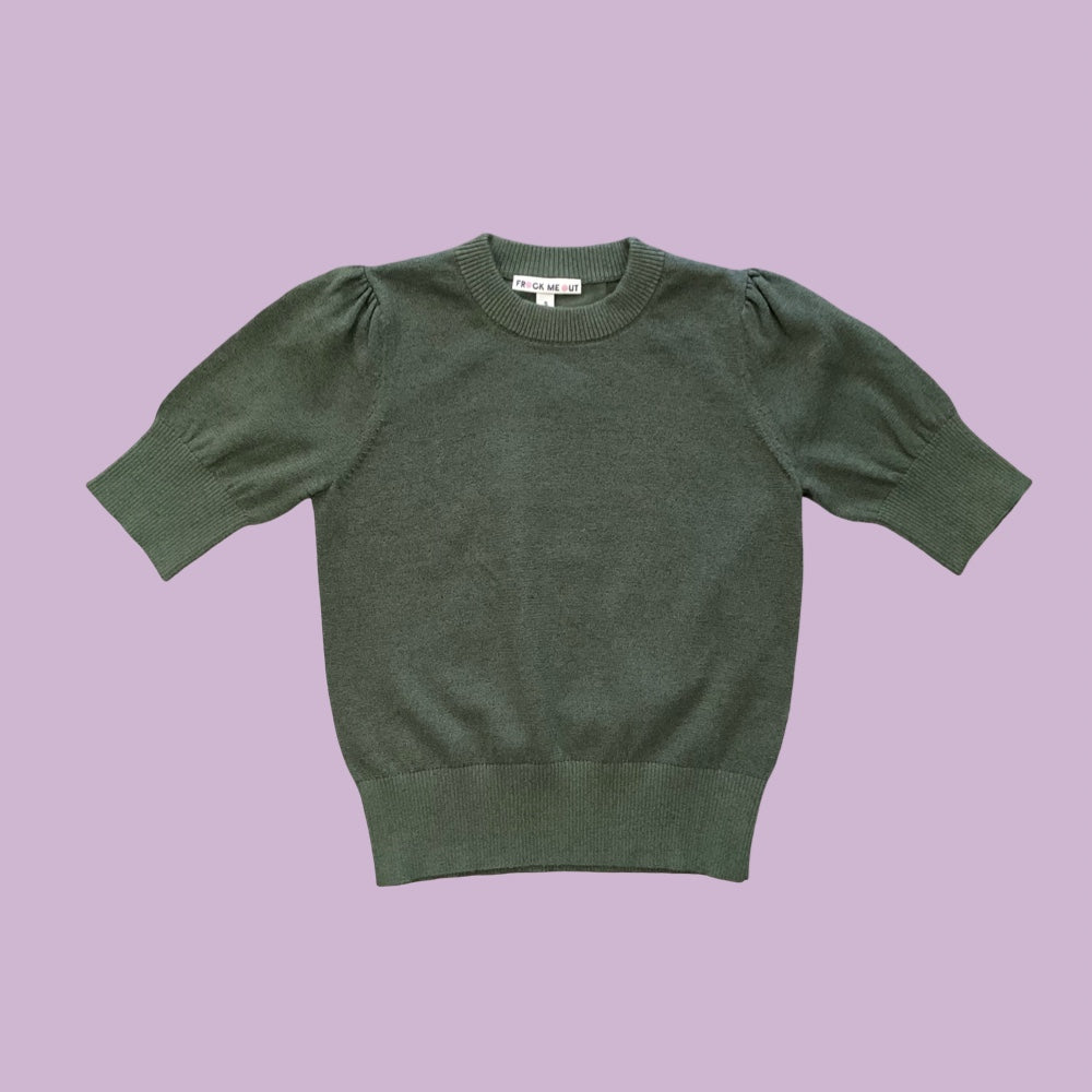 Frock Me Out Lurex Knit, a short-sleeved knit with puff sleeves in Olive, on a pale lilac background