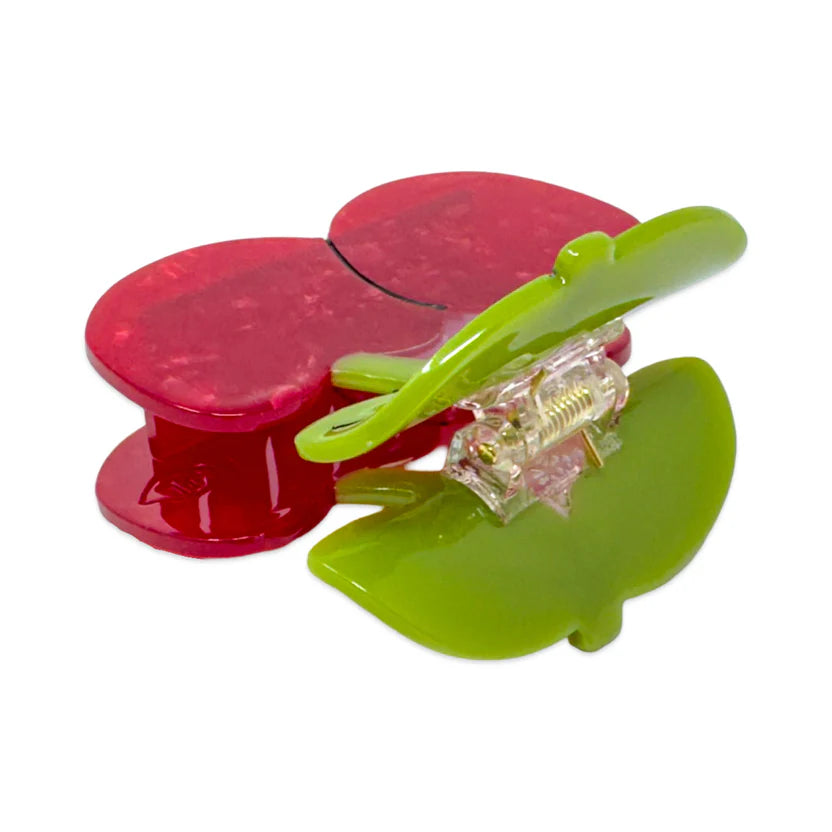 Green and red cherries hair clip on a white background