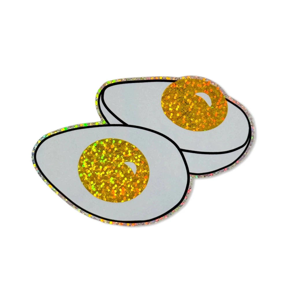 Two cartoon-style eggs with glittery yolks on a white background