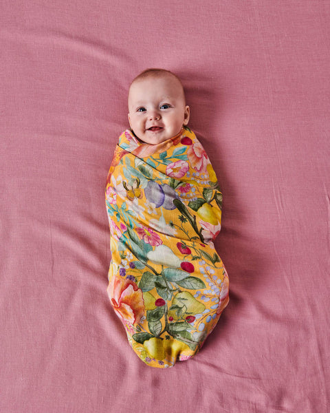 Kip & Co Abundance Marigold Bamboo Baby Swaddle modelled by baby.