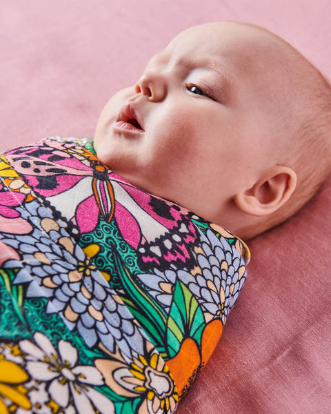 Close up of Kip & Co Bliss Floral Bamboo Baby Swaddle modelled by baby