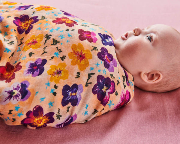 Close up of Kip & Co Pansy Bamboo Baby Swaddle modelled by baby