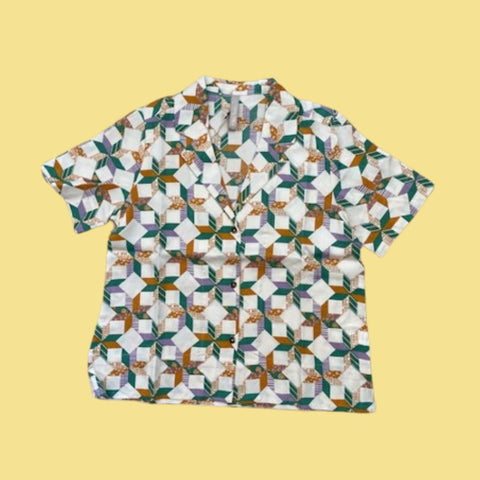 Mata Traders Camp Shirt in Pinwheel. It as a collar and is a button-down shirt.