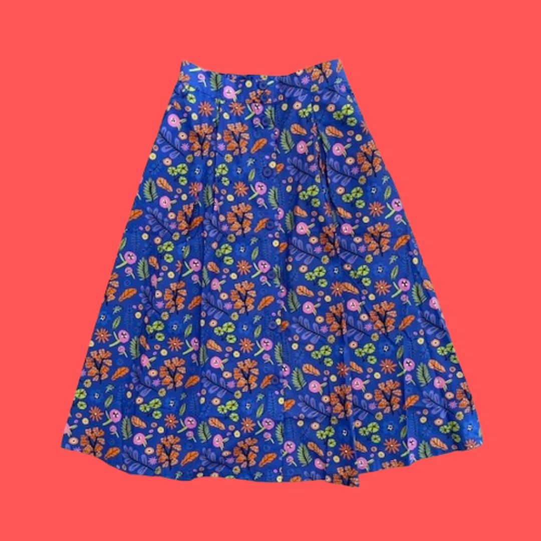 Floral patterned skirt predominantly blue-purple with red and pink flowers and green leaves on a red background
