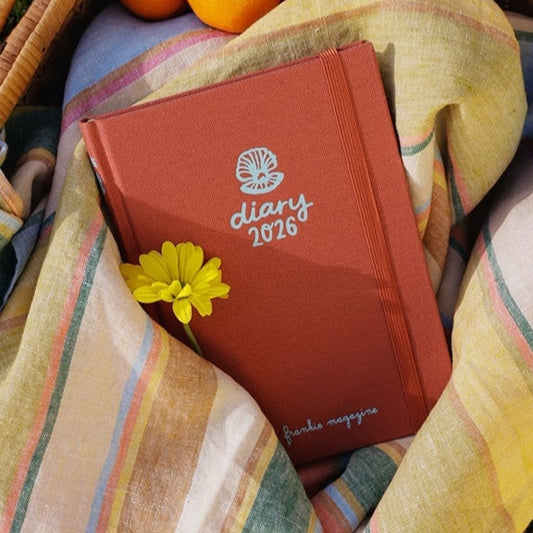 Frankie Diary 2026 nestled in striped linen fabric with a yellow flower.