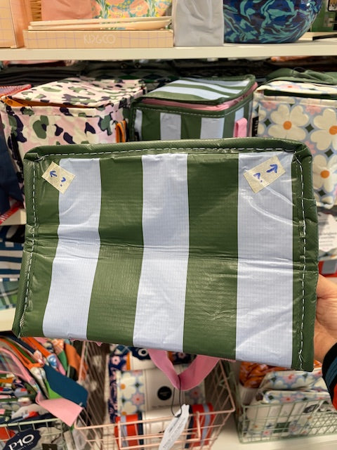 Base of the tote with arrow stickers pointing to the two corners where the trimming has not been sewn well. 