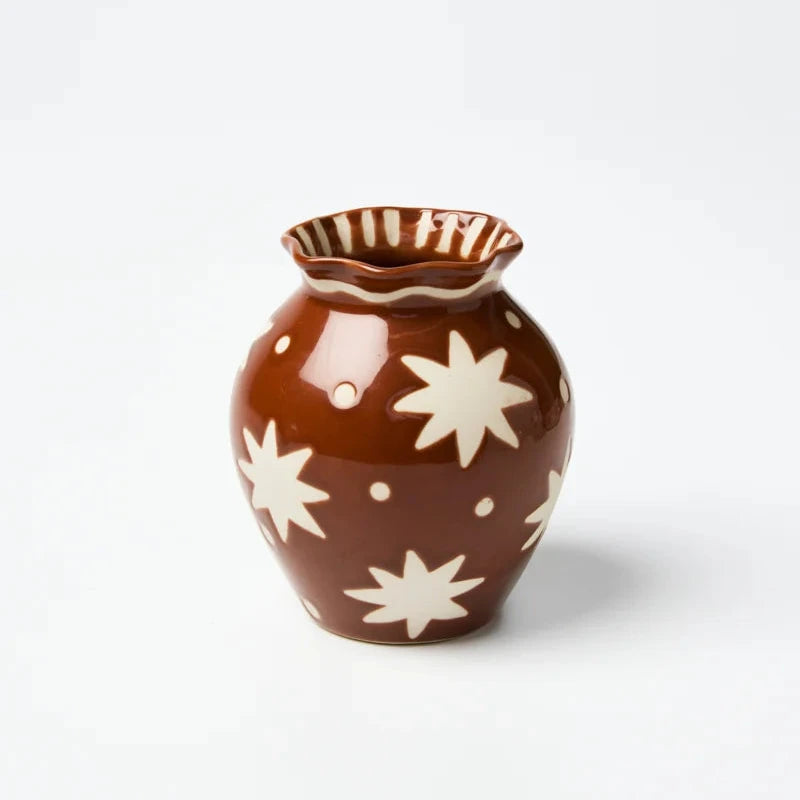 Brown ceramic vase with white star patterns on a white background