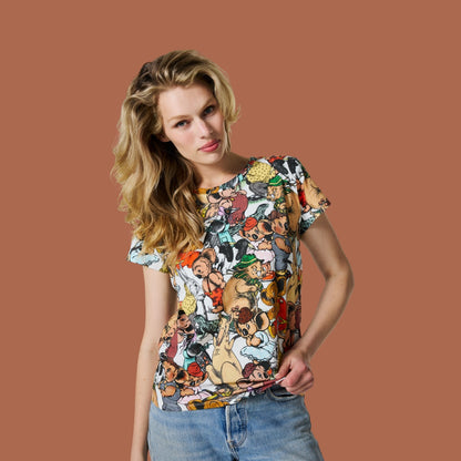 A woman modeling a short-sleeve t-shirt with a dense, colorful Blinky Bill cartoon character print, paired with blue jeans, set against a solid terracotta background.