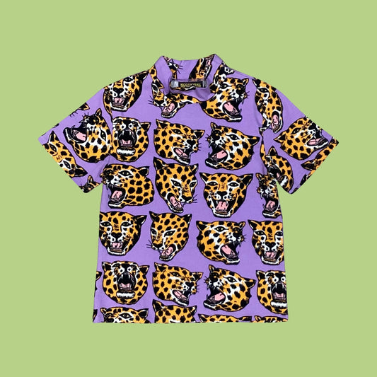 Nooworks lilac-coloured short-sleeve mock next top with an all-over print of cheetah heads on a green background