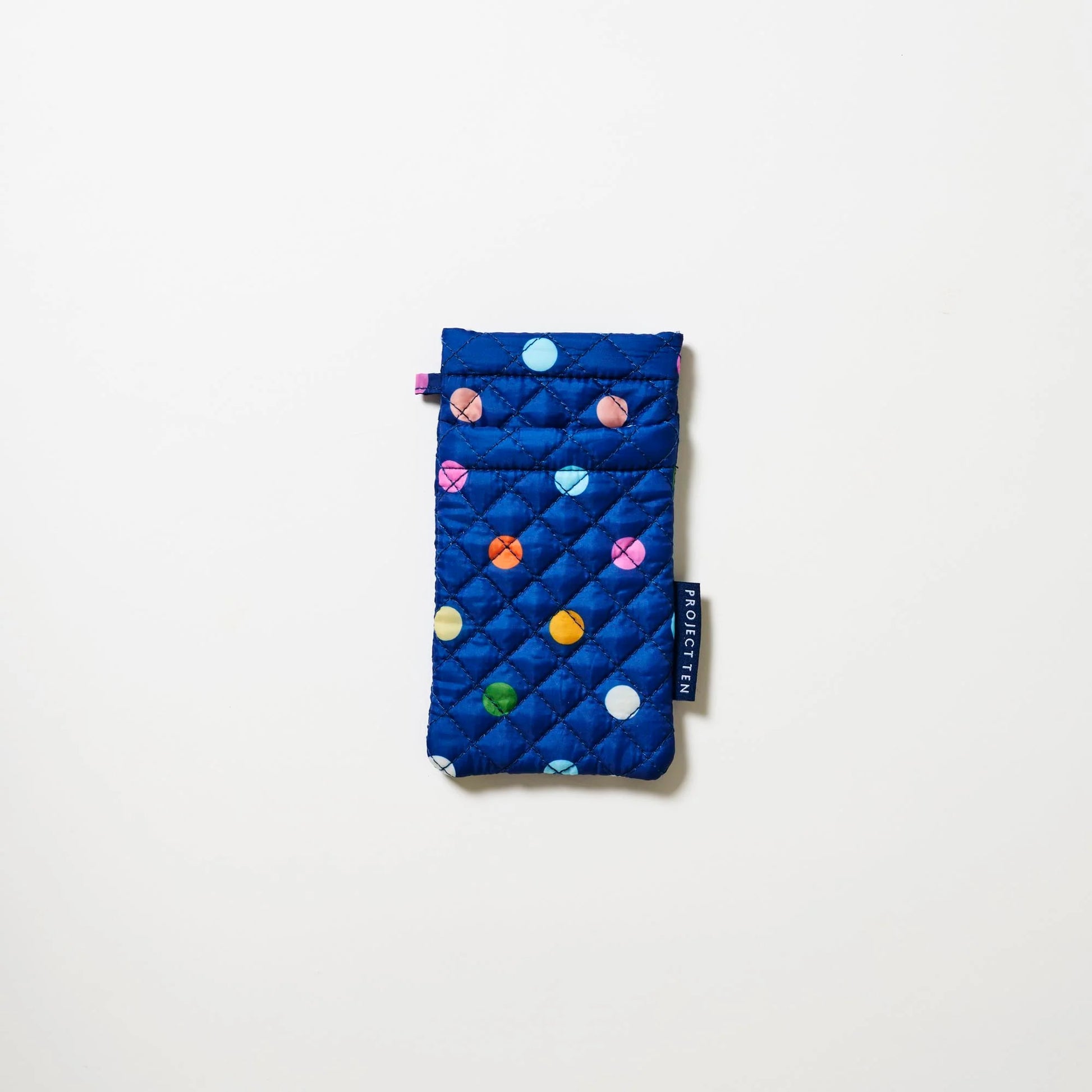 Blue quilted glasses pouch with colorful polka dots on a white background