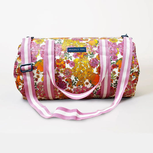 Floral patterned duffel bag with pink straps on a white background