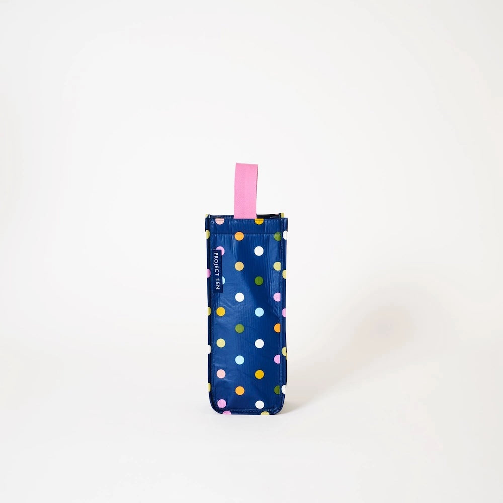 Navy blue umbrella with colorful polka dots and a pink handle on a white background