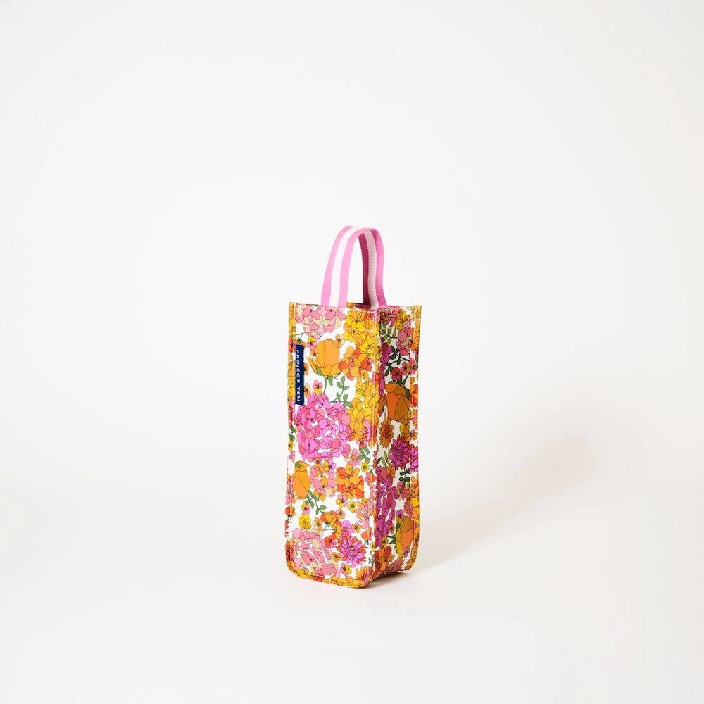 Floral-patterned wine bag with pink and white handle on a white background