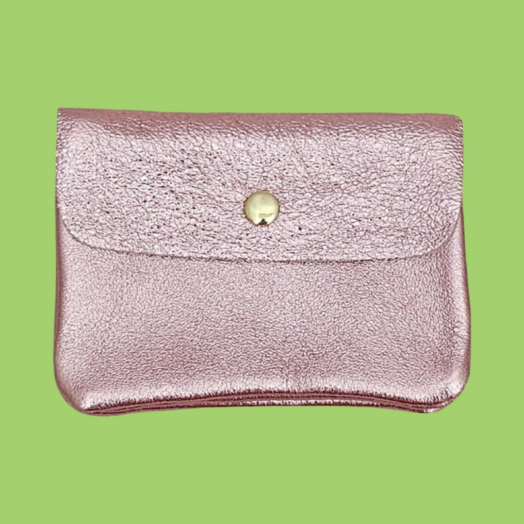 A metallic light pink envelope-style wallet with a textured leather finish and a gold snap button, shown against a solid light green background.