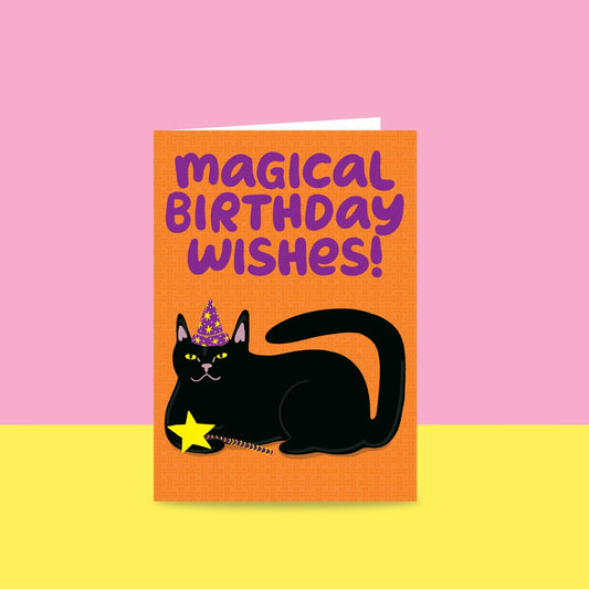 Able & Game Magical Birthday Wishes Cat Card featuring a black cat laying with a star wand in its paw and wearing a purple and yellow witch's hat