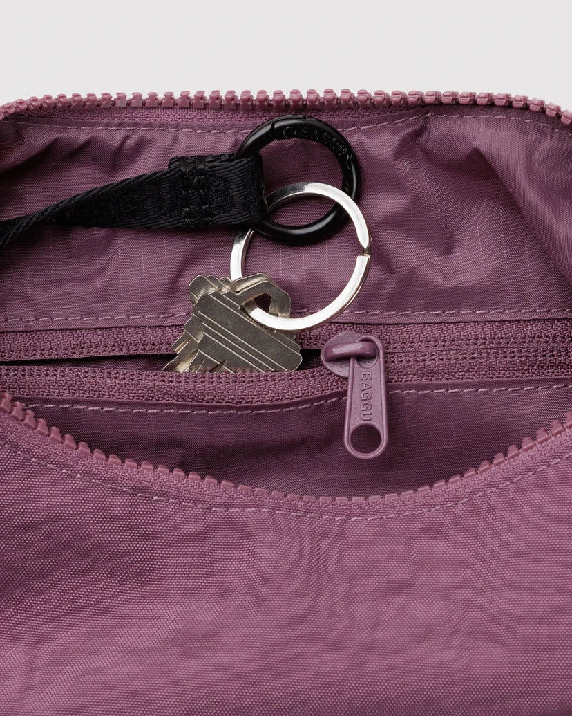 Close up of the Plum Purple bag featuring the inner lining showing a zipper pocket and keychain.