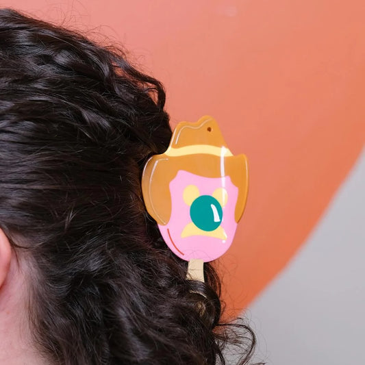 Hair claw shaped like Bubble O' Bill ice cream in dark wavy hair.