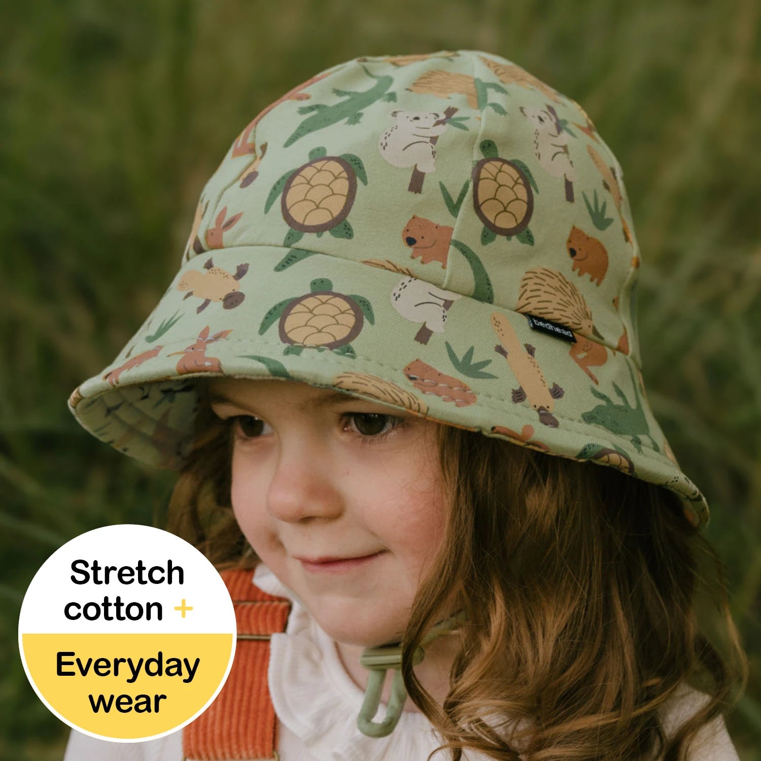 Toddler wearing a Australian animal patterned bucket hat with a natural background