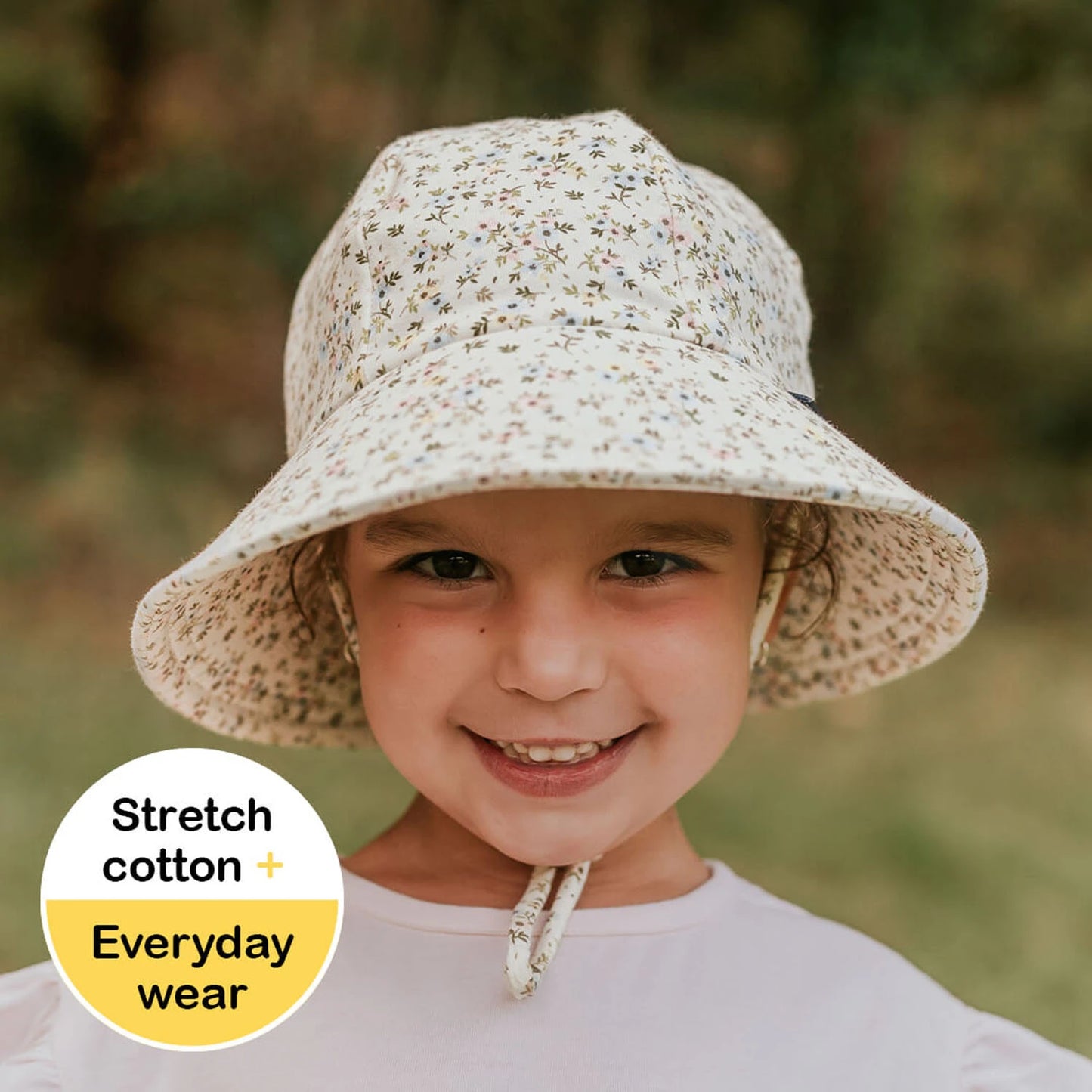 Child wearing a floral bucket hat with text about stretch cotton and everyday wear.
