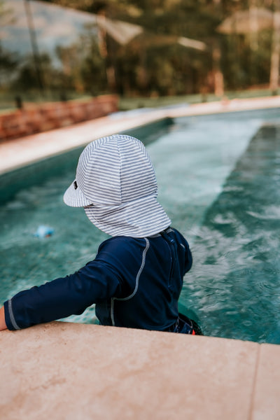 back view of Bedhead Stevie Stripe Swim Legionnaire Hat worn by a young model in a swimming pool