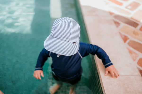 Top view of Bedhead Stevie Stripe Swim Legionnaire Hat worn by a young model in a swimming pool