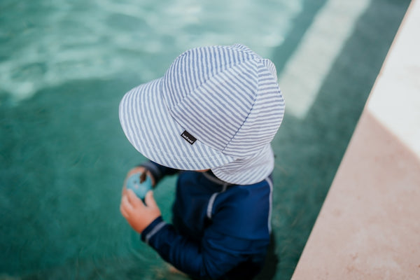 Side view of Bedhead Stevie Stripe Swim Legionnaire Hat worn by a young model in a swimming pool