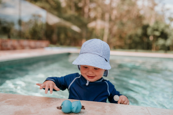 front view of Bedhead Stevie Stripe Swim Legionnaire Hat worn by a young model in a swimming pool