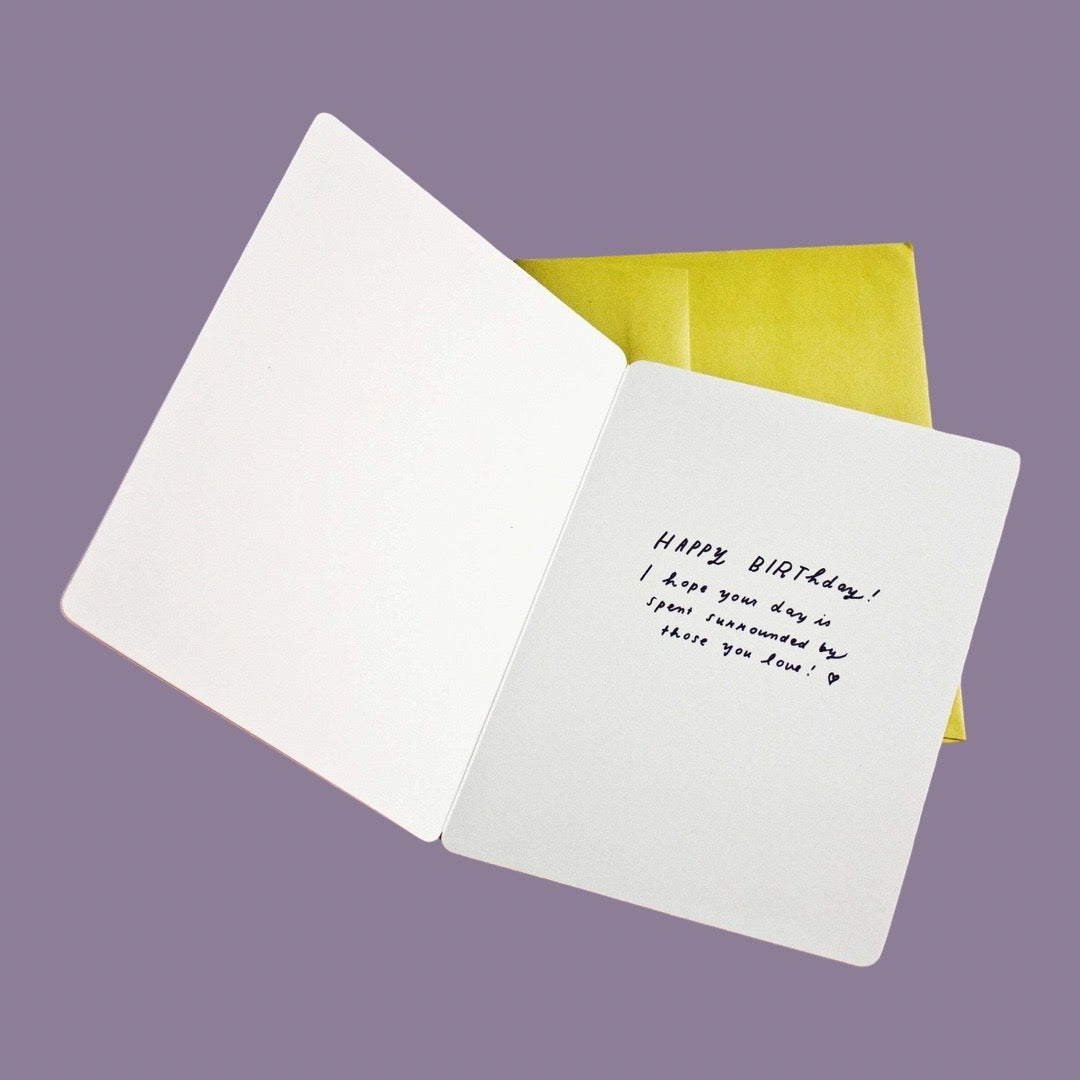 The inside of the card features black text in a handwritten font on the right page that reads: Happy Birthday! I hope your day is spent surrounded by those you love!