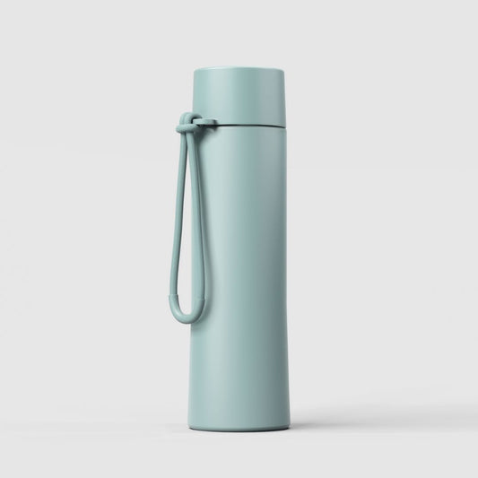 A Fressko Ceramic Interior MOVE Drink Bottle - 660ml in Breezy, matte aqua blue-green insulated travel tumbler with a matching carrying loop and lid, shown on a clean white background.