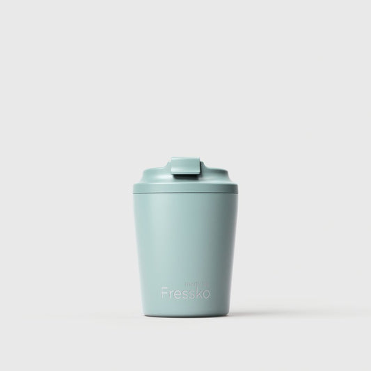 A light sea foam blue-green insulated travel tumbler with a matching flip-top lid, featuring the 'Fressko' brand name printed in white near the bottom, set against a clean, light gray studio background.