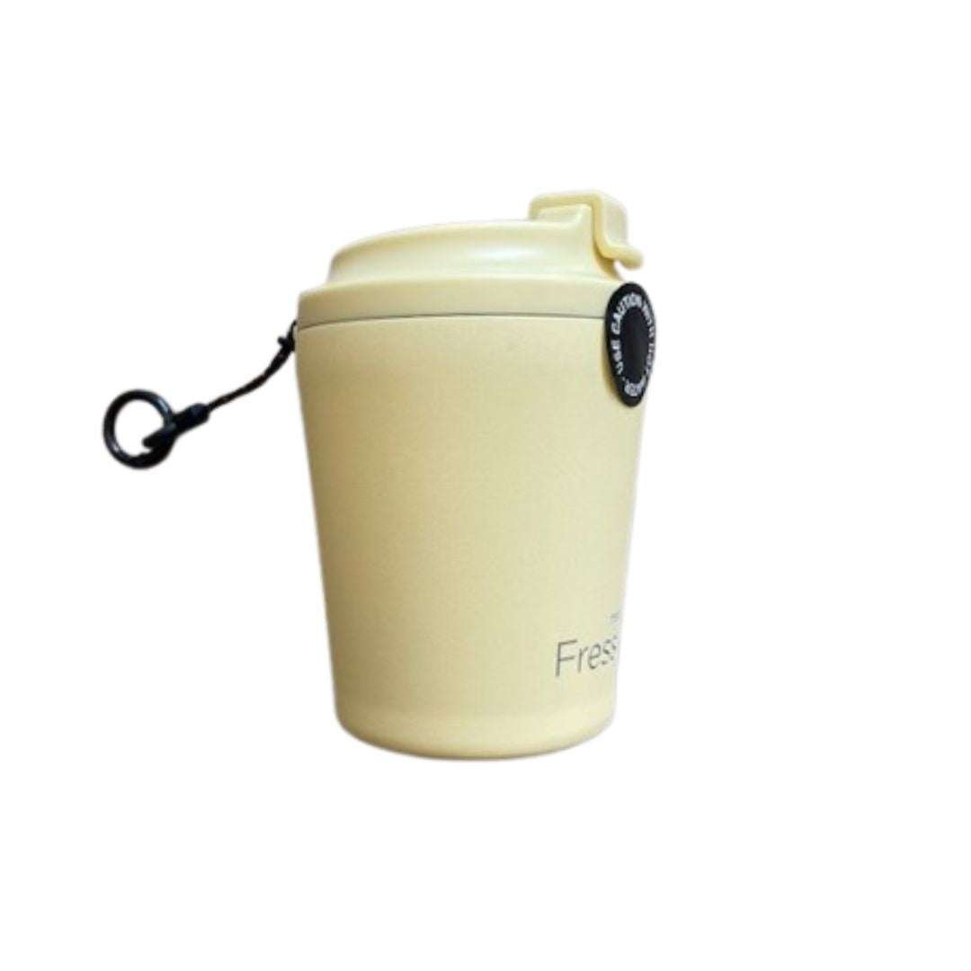 Light yellow reusable cup with a black hang loop on a white background