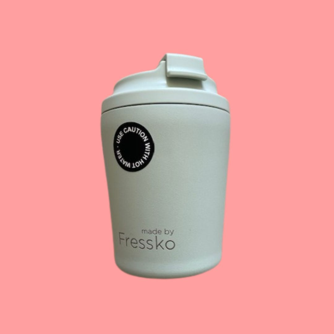 Light green reusable cup with 'made by Fressko' label on a pink background