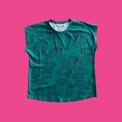Frock Me Out Labyrinth Capped Sleeve Tee - Green sleeveless shirt with navy blue geometric pattern on a pink background
