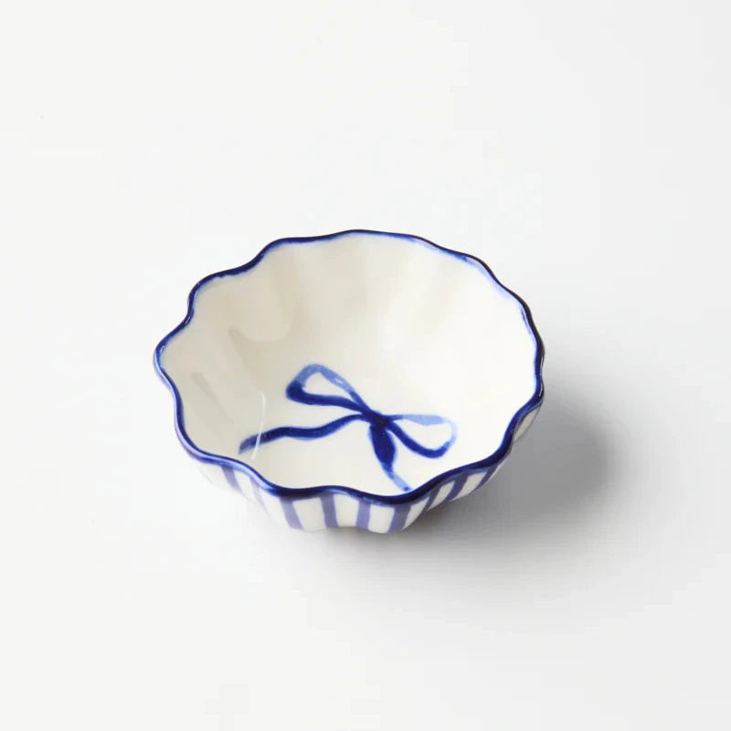 Small ceramic bowl with blue decorative elements on a white background