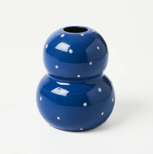 Blue ceramic vase with white polka dots on a white background