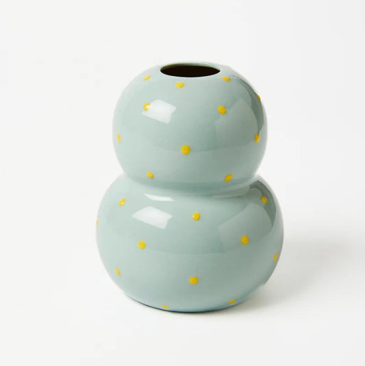 Light blue ceramic vase with yellow polka dots on a white background