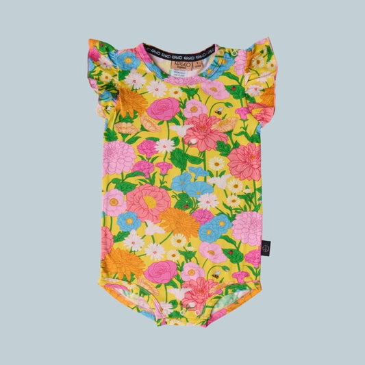 Kip & Co Follow the Sun Yellow Short Sleeve Frill Romper - a colorful floral-patterned baby romper on a light gray background