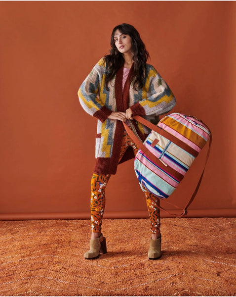 Model is holding Kip & Co Jaipur Stripe Duffle Bag in her hands