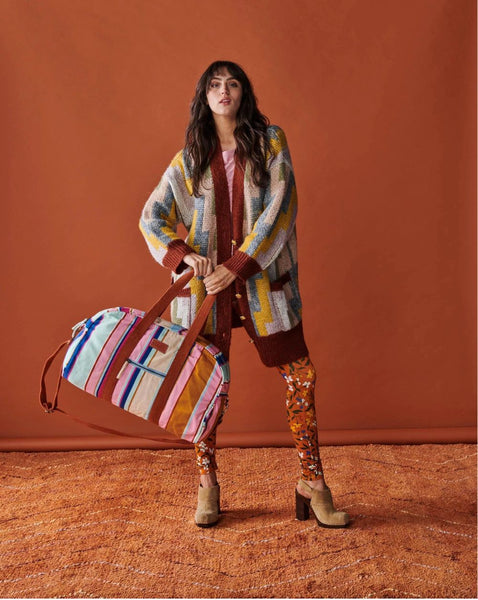 Model is holding Kip & Co Jaipur Stripe Duffle Bag in her hands