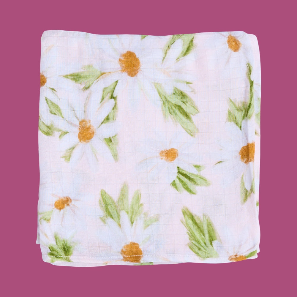 Floral patterned baby swaddle folded on a purple background