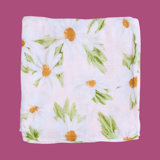 Floral patterned baby swaddle folded on a purple background