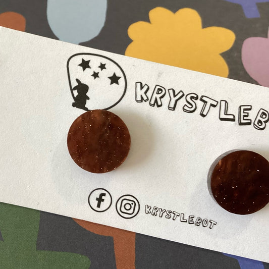 Close-up of brown round studs with a subtle shimmer throughout on a Krystlebot branded card