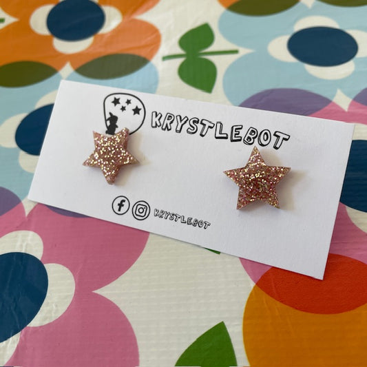 Krystlebot Star Studs - Peach Glitter. A pair of star shaped earrings in pale pinky-brown glitter on a Krystlebot backing card.