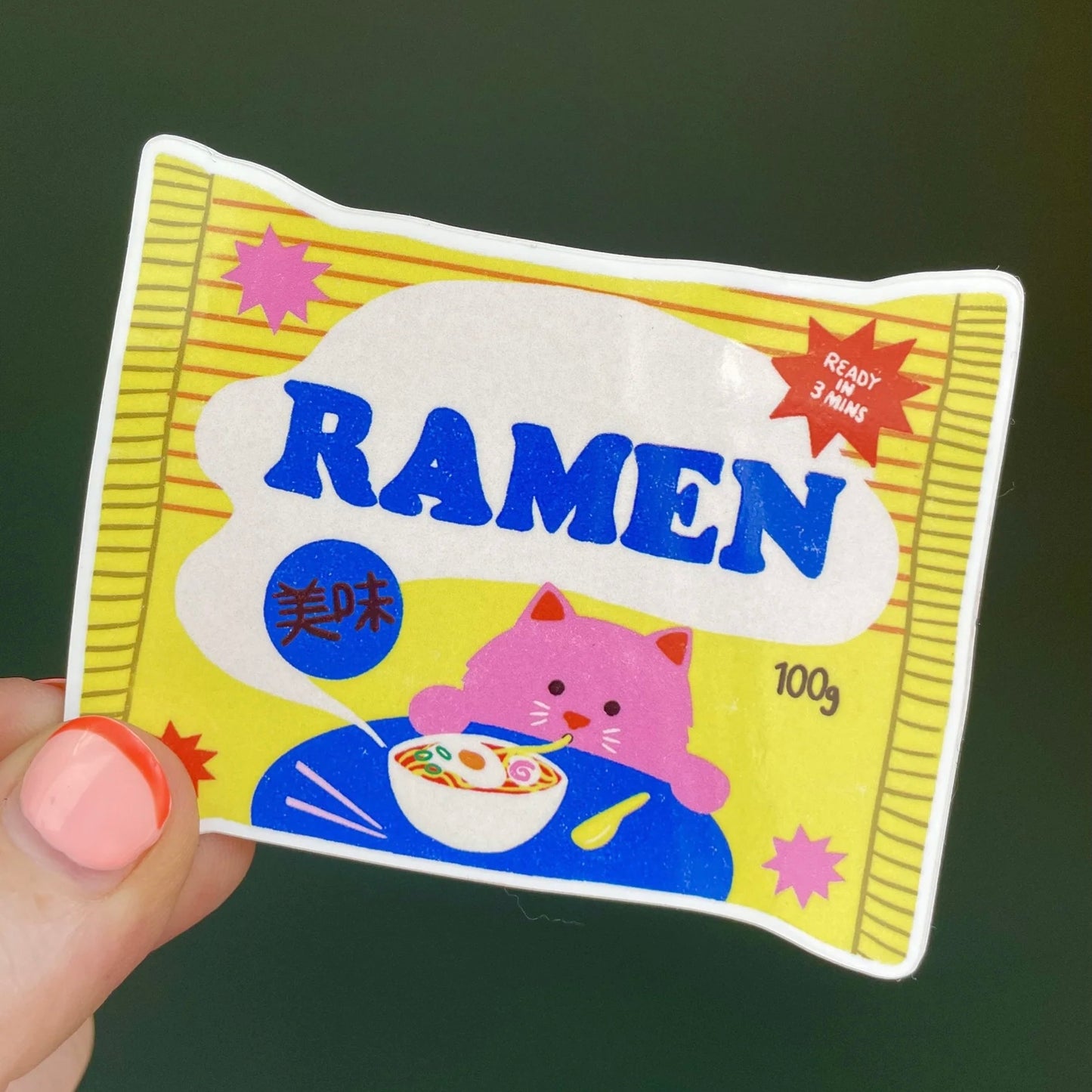 Sticker by Naomi Wilkinson of a ramen packet with a cat character on a dark background