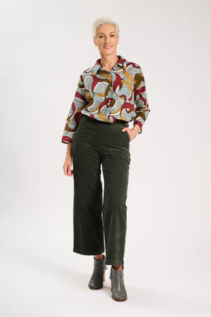 Model is wearing Dark khaki green velvet pants with a colourful pattern shirt